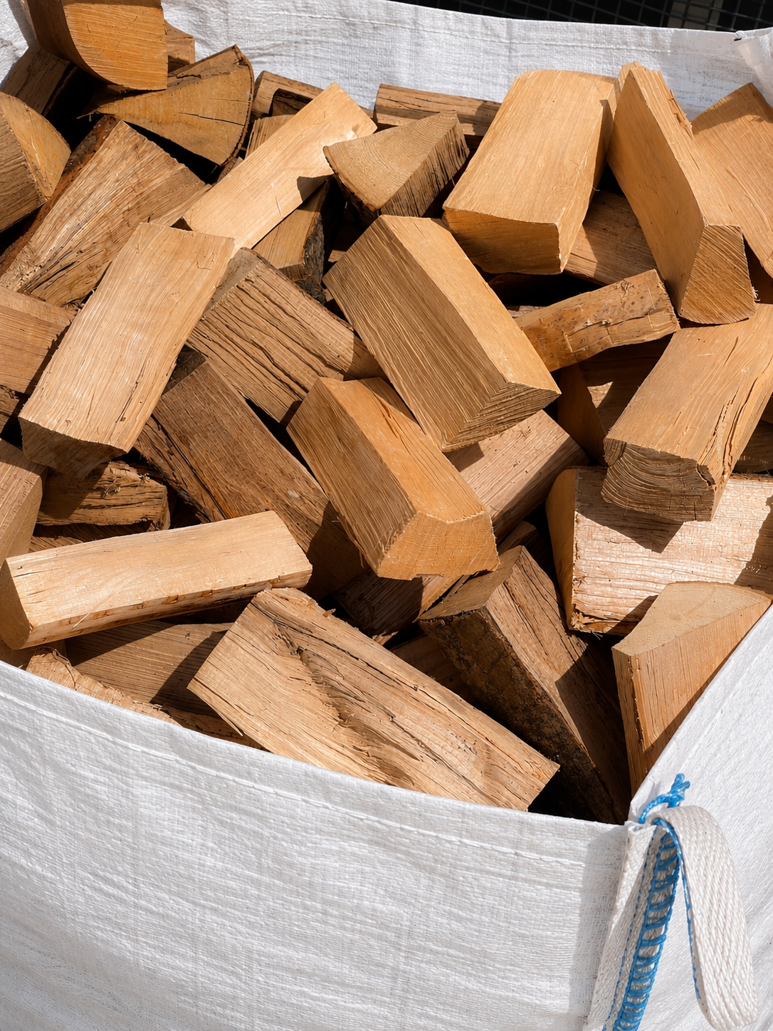 Close up of seasoned hardwood logs filling a Ferring Firewood bulk bag.