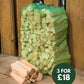 Net bag of kindling propped against fence, with loose split kindling sticks beside it and a badge reading 3 for £18.